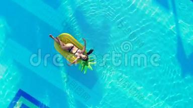 一个人在游泳池里休息，漂浮在橡胶床垫上。 泳池里的无忧无虑的女人。